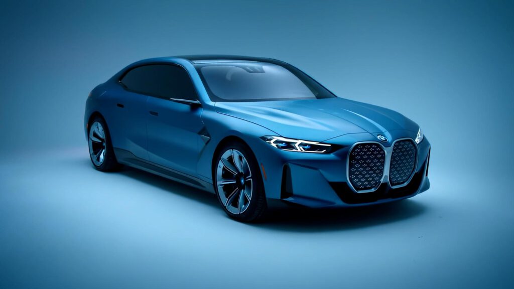 A sleek, modern blue sedan with a large front grille and sporty design, displayed in a studio setting with a blue background and soft lighting. AI Image made by Christian Fleischer / The Visiblemaker